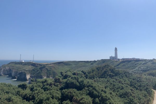 Flamborough head cliffs looking out onto the seafront in the UK, with a lighthouse